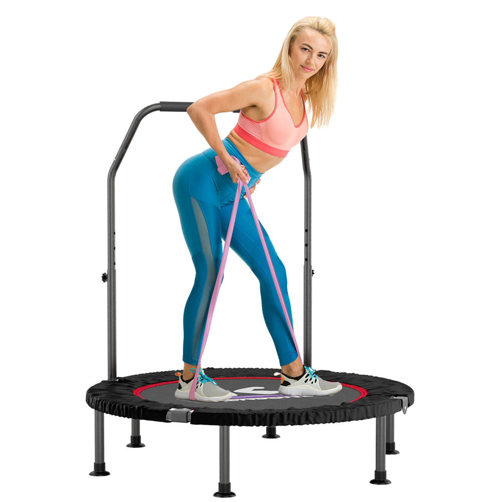 A person exercising on a 40-inch mini trampoline with a pink and black color scheme. The trampoline has a steel frame, adjustable handles, and a black mat.