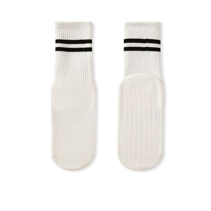 A pair of white no-slip grip tall socks with black stripes on the side, displayed against a white background.