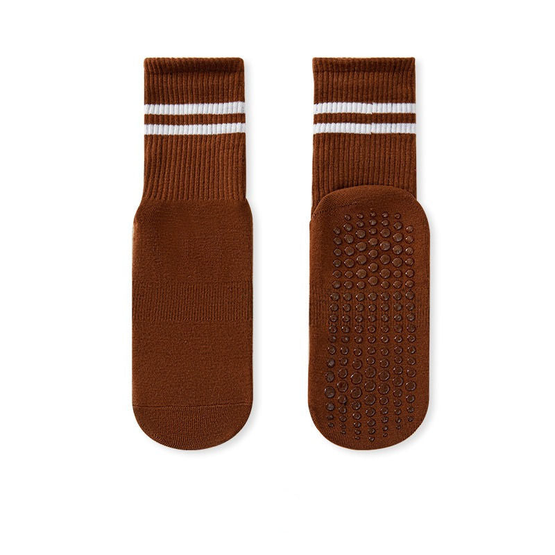 A pair of brown no-slip grip socks with a striped elastic band at the top and a textured surface for grip.