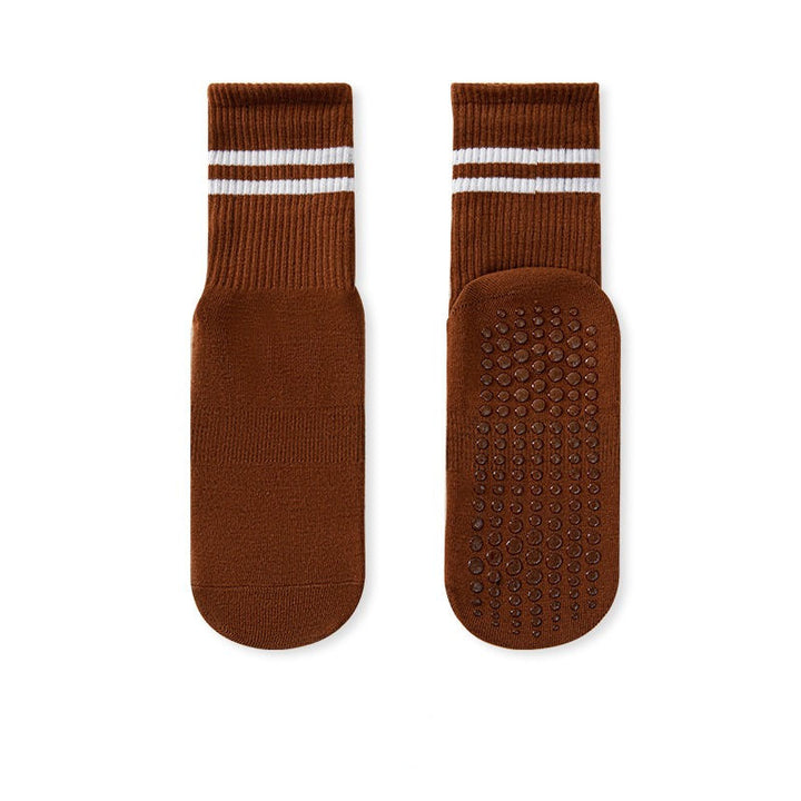 A pair of brown no-slip grip socks with a striped elastic band at the top and a textured surface for grip.