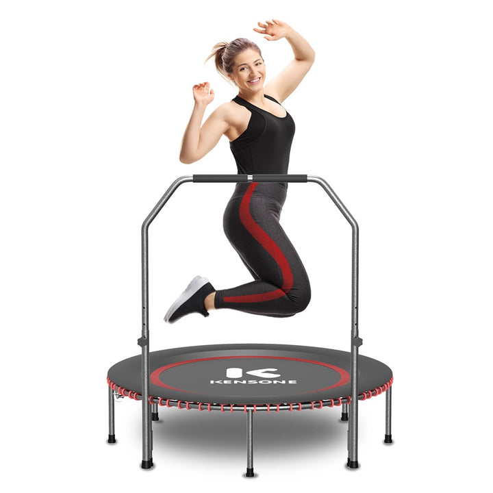 A woman exercising on a round red and black trampoline with a safety enclosure net and a brand logo 'KENSONE' in the center.