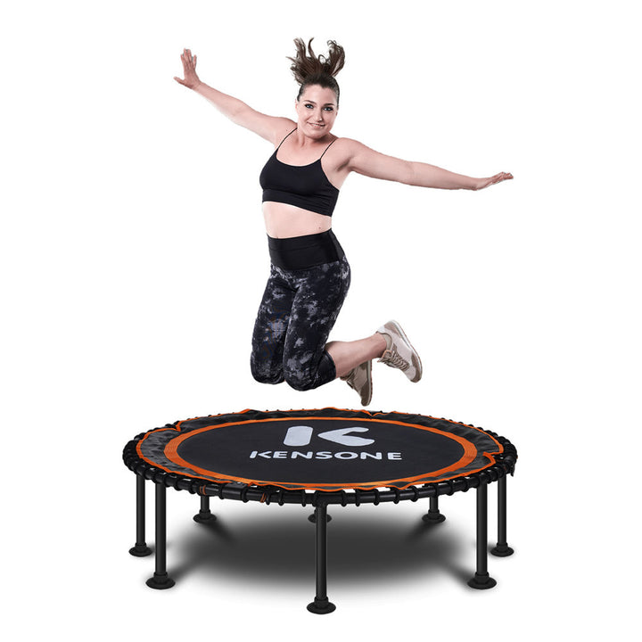 Woman jumping on a Kensone orange bungee trampoline with a white background
