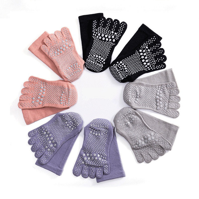 Set of four pairs of toe separators in pink, black, gray, and purple on a white background.
