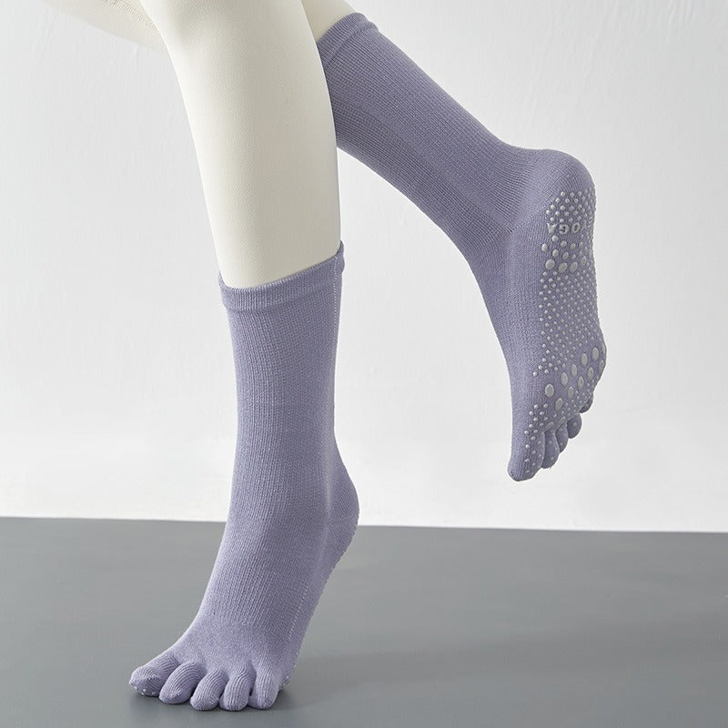 Purple socks with toe separation on a neutral background