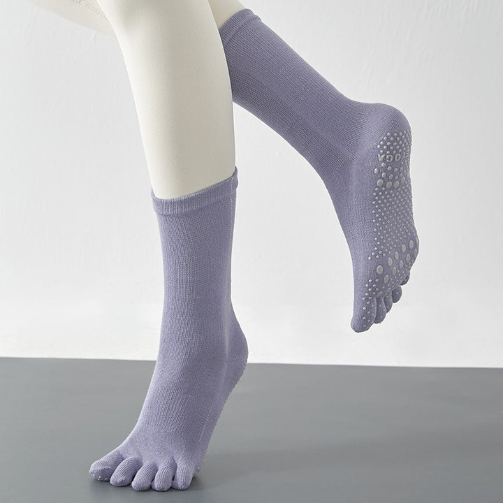 Purple socks with toe separation on a neutral background