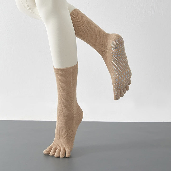 Beige socks with toe separation on a plain background